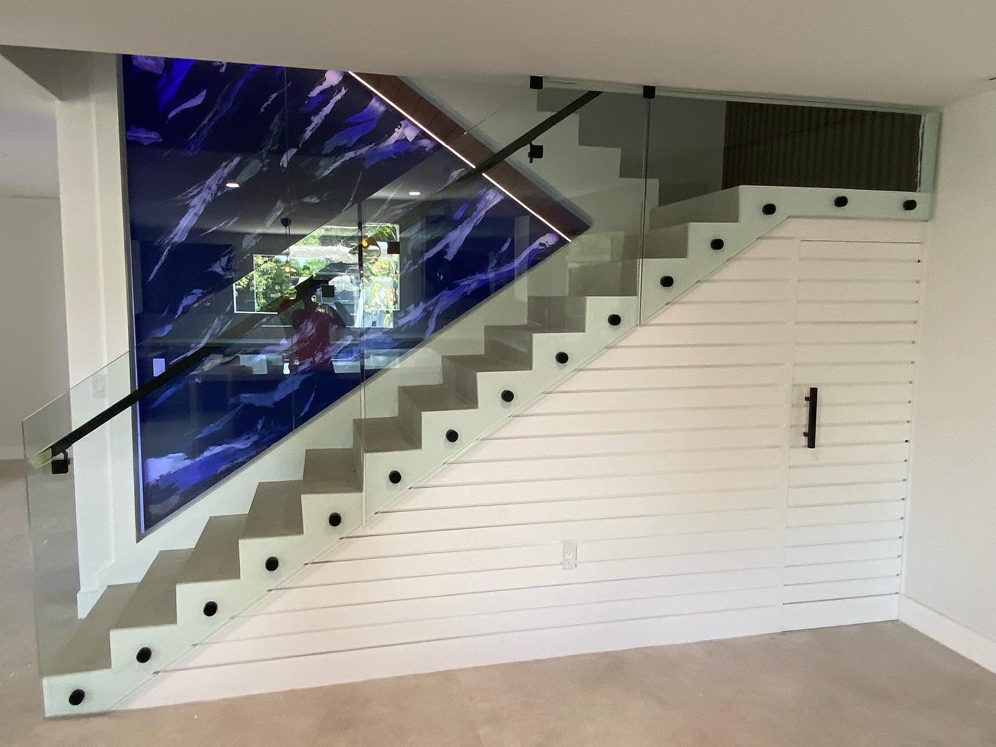Architectural glass installation beside an illuminated feature wall